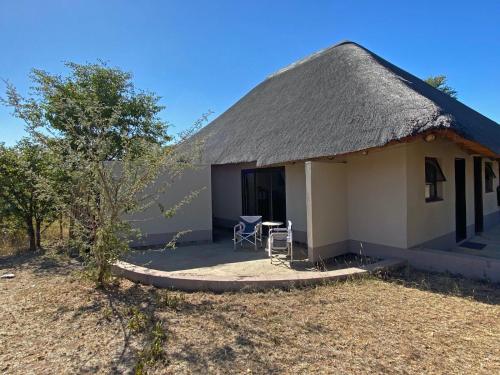 a small house with a thatched roof and a patio at Lengau Lodge in Grietjie Nature Reserve