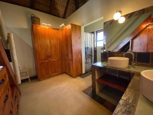 a bathroom with wooden cabinets and a sink in it at Lengau Lodge in Grietjie Nature Reserve