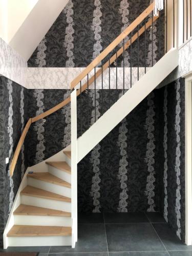 a staircase in a house with black and white wallpaper at B&B De Gulden Halsband Pingjum in Pingjum