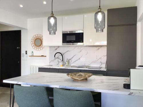 a kitchen with a table with chairs and a sink at Salsa LUXE Terrasse et Parking Plages à 100m BEST OF JUAN in Juan-les-Pins