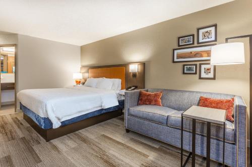 シーダーラピッズにあるHampton Inn Cedar Rapidsのベッドとソファ付きのホテルルーム