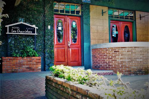 a red door of a building with a sign on it at Boutique Hotel Casa Orquídeas in San José