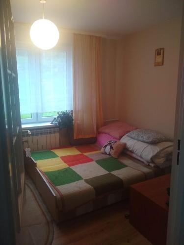 a small bedroom with a bed and a window at U STASI kwatery in Piwniczna-Zdrój