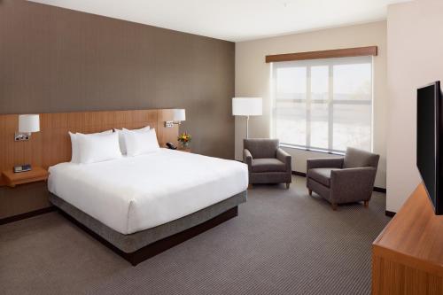 a bedroom with a bed and a chair and a television at Hyatt Place Florence Downtown in Florence