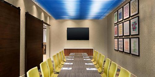 a conference room with a long table and yellow chairs at Holiday Inn Express & Suites - Kokomo South by IHG in Kokomo
