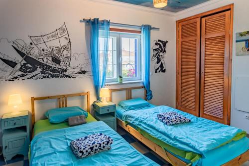 1 dormitorio con 2 camas y ventana en Captains Log House, en Baleal