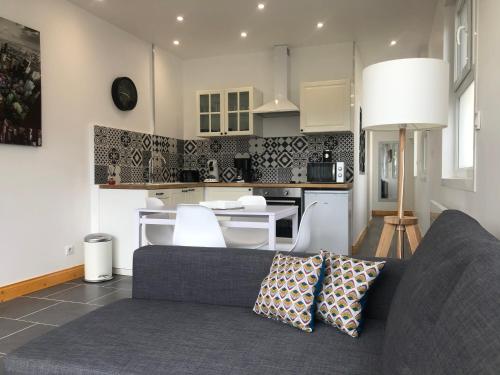 un salon avec un canapé et une cuisine dans l'établissement Appartement avec jardin, à Isbergues