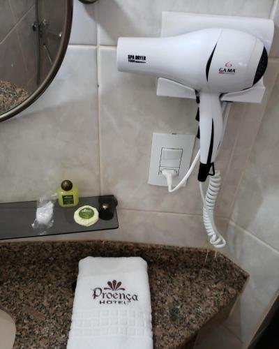 a white hair dryer sitting on a counter in a bathroom at Proença Hotel in Barretos