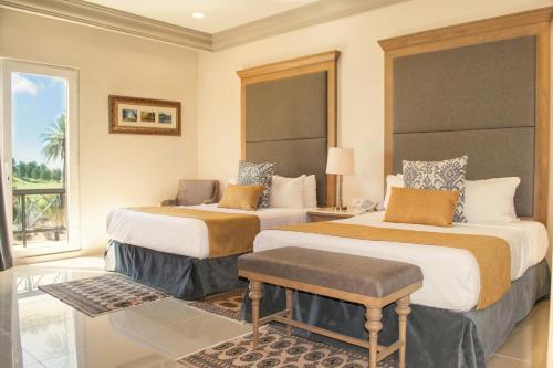 a hotel room with two beds and a window at Azul Talavera Country Club in Torreón