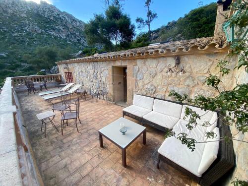 a patio with a couch and chairs and a table at Finca Ses Fontanelles in Andratx