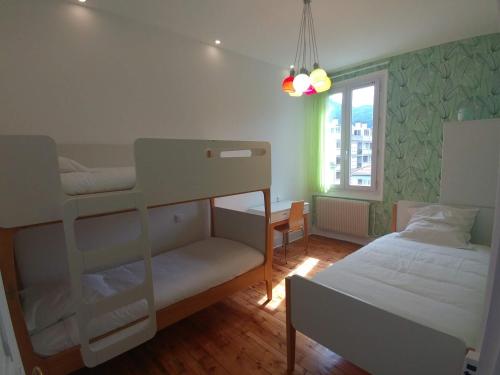 Un dormitorio con dos literas y una ventana. en Confort douceur et calme dans Grenoble, en Grenoble
