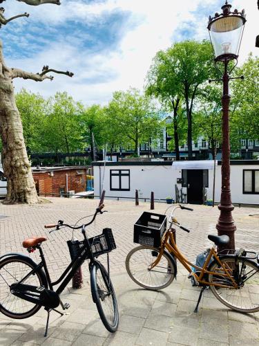 two bikes are parked next to a light pole at Amsterdam-Houseboat-Amstel in Amsterdam