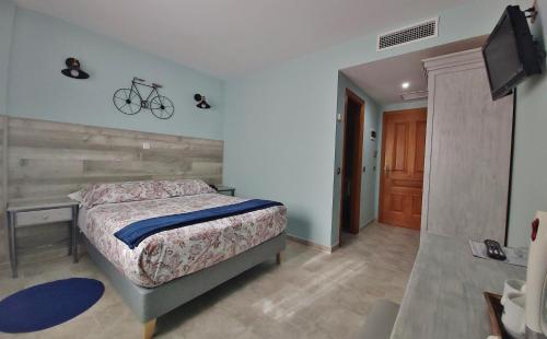 a bedroom with a bed and a bike on the wall at Posada Del Camino Real in Torrelaguna