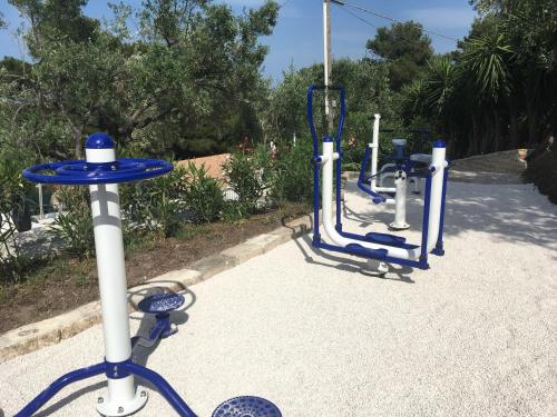 a row of blue and white exercise machines on a sidewalk at Viestemare Resort & SPA in Vieste