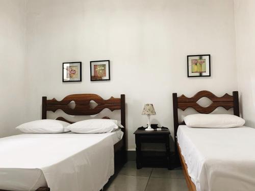 two beds sitting next to each other in a bedroom at Casa Centro Histórico in São João del Rei