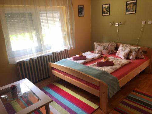 a bedroom with a bed with two dolls on it at Leander Apartman Balatonakali in Balatonakali