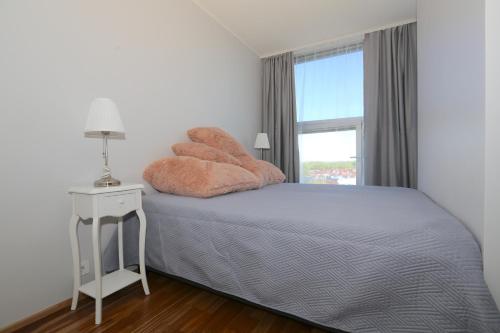 1 dormitorio con 1 cama con 2 almohadas y ventana en Lys Apartments City Center, en Pärnu