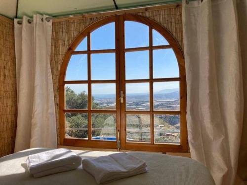 a bedroom with a large window with two pillows on a bed at Treehouse ,Casa Arbol, with Spa in Algarrobo