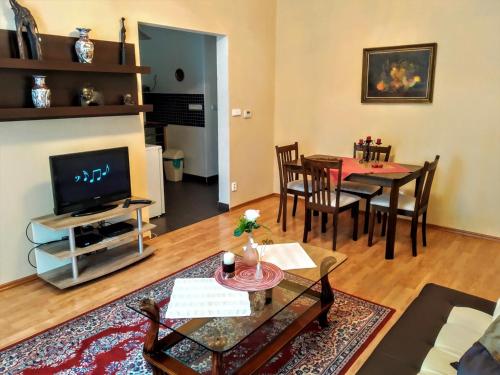 a living room with a table and a television at Apartment Sense of Zizkov in Prague