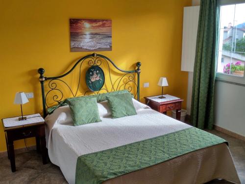 ein Schlafzimmer mit einem Bett mit einer grünen Bettdecke in der Unterkunft B&B L'Asfodelo in Villa San Pietro
