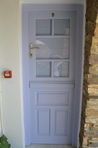 a blue door with glass panels in a hallway at Studio Ioanna Tinos in Kionia