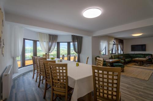 a dining room and living room with a table and chairs at Acasa la Mariuca in Bran