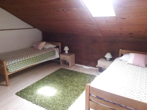 Habitación en el ático con 2 camas y alfombra verde en Apartmani Dominik, en Zadar