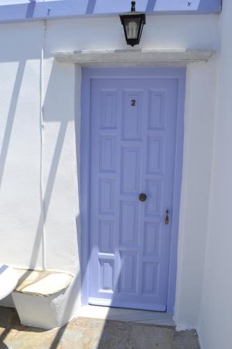 a purple door on a white house at Studio Ioanna Tinos in Kionia