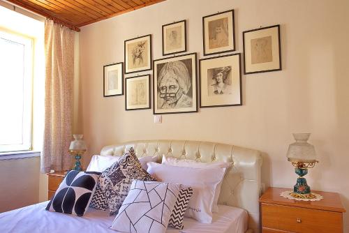 - une chambre avec un lit et des photos encadrées sur le mur dans l'établissement Nona's House, à Corfou