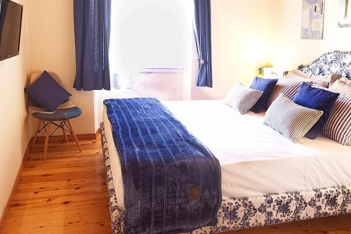 a bedroom with a bed with a blue blanket on it at Nona's House in Corfu Town