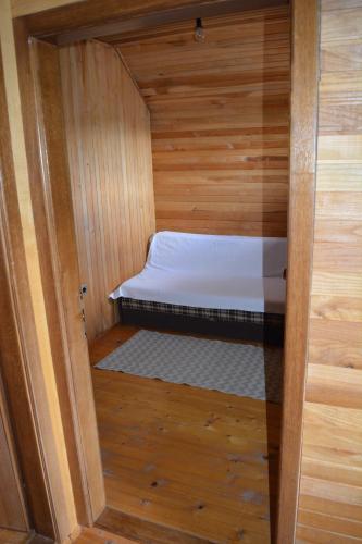 a small room with a bed in a wooden cabin at Vila Mira Zlatar in Nova Varoš