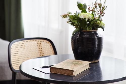 a table with a book and a vase with flowers at Kvosin Downtown Hotel in Reykjavík
