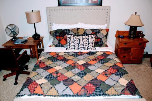 a bedroom with a bed with a quilt on it at Iowa House Historic Inn in Ames