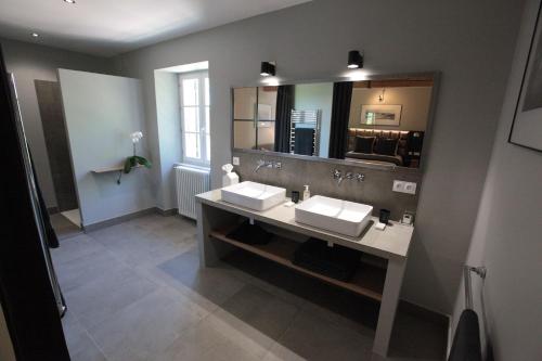 une salle de bain avec deux lavabos et un grand miroir dans l'établissement Maison Gascony, à LʼIsle-de-Noé