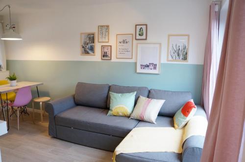 a living room with a blue couch with pillows at The Oldbrook Garden Flat in Milton Keynes