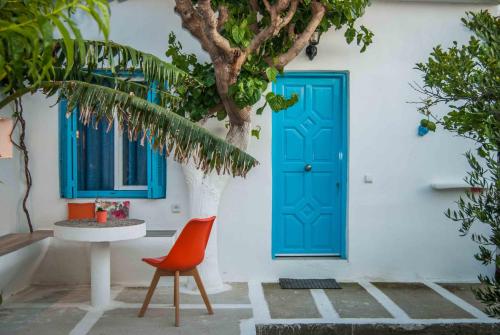a blue door on a white building with a table and a chair at PERIVOLI 4-CHORA(5min away from the center by car) in Agkidia