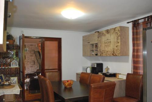 a kitchen with a table and chairs and a counter at Vila Magnolia in Curtea de Argeş