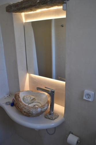a bathroom with a sink with a mirror at Studio Ioanna Tinos in Kionia