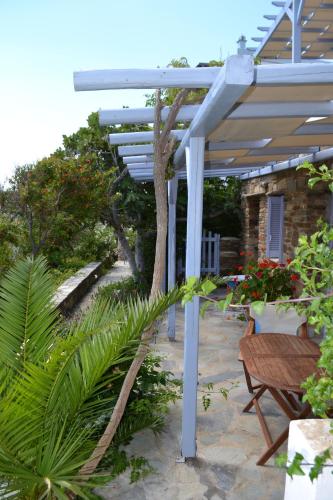 a white pergola with a table and a bench at Studio Ioanna Tinos in Kionia
