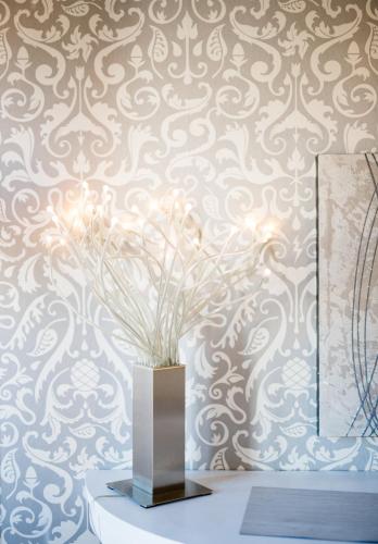 a vase on a table in front of a wallpaper at Casale D' Or in Palermo