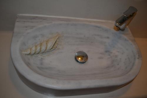 a white sink with a spoon and a spork in it at Studio Ioanna Tinos in Kionia