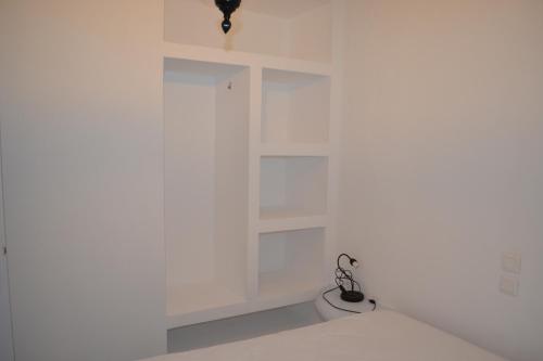 a room with white walls and white shelves at Studio Ioanna Tinos in Kionia