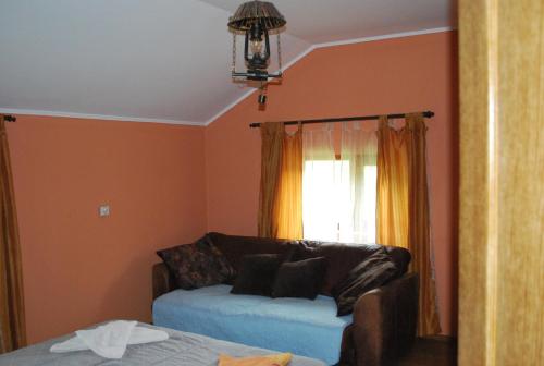 a living room with a couch and a window at Vila Magnolia in Curtea de Argeş
