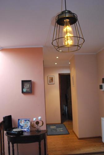 a living room with a table and a chandelier at Vila Magnolia in Curtea de Argeş