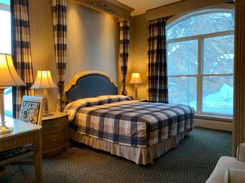 a bedroom with a bed and a large window at Celebrity Hotel in Deadwood
