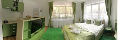 een kleine slaapkamer met een bed en een televisie bij Casa Hera in Sinaia