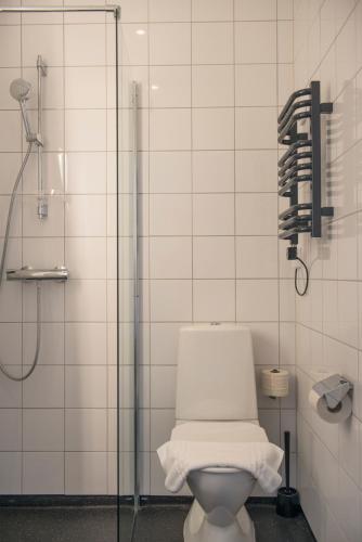 a bathroom with a white toilet and a shower at Hotell Kneippbyn Resort Visby in Visby