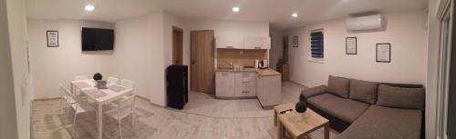 sala de estar con sofá y cocina en Ady Apartmanház, en Orfű