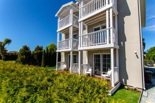 a large white house with white balconies at Willa Verano in Karwia