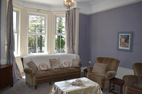 a living room with a couch and two chairs at Church View Manor in Tullynamalra Cross Roads